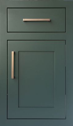 a green cabinet door with brass handles and knobs