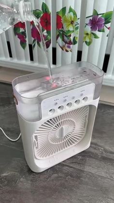 an air conditioner sitting on top of a counter next to a flowered wall