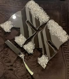 three pieces of cake sitting on top of a glass plate with pearls and silver decorations