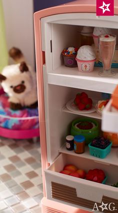 a small toy refrigerator with food in it's door and a stuffed animal on the other side