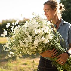 a woman holding a bouquet of white flowers