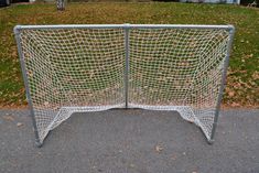 two metal soccer goal posts sitting on the side of a road in front of a house