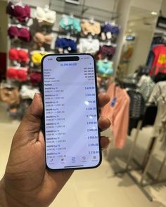 a person holding up an iphone in a store