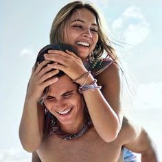 a woman holding onto another woman's shoulders while she smiles at the camera with her hands on her head