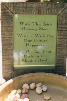 a stone bowl with rocks in it and a sign that says, with this irish blessing stone write a wish for our future happiness by placing your rock in the