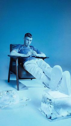 a man sitting in a chair with his feet up on a table next to ice cubes