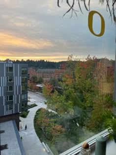 the view from an apartment window looking out onto a campus with trees and buildings in the background