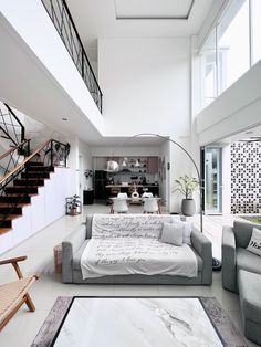 a living room filled with furniture next to a stair case in a white walled house