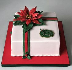 a decorated christmas present box on a red and white plate with green trimmings