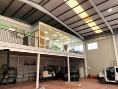 the inside of a garage with several vehicles parked in front of it and an open roof area