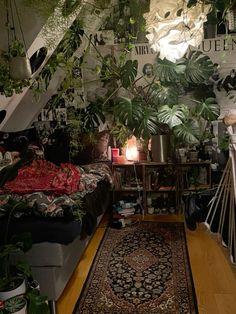 a room filled with lots of plants next to a stair case and rug on top of a hard wood floor