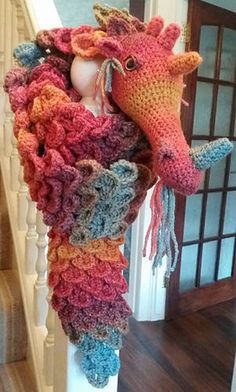 a crocheted sea horse head hanging from the side of a stair case in a house