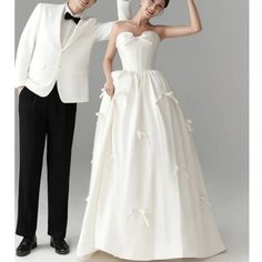 a man in a tuxedo standing next to a woman in a wedding dress