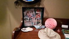 a hat and other items are sitting on a desk in front of a framed photo