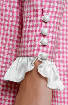 a woman's pink and white checkered shirt with buttons