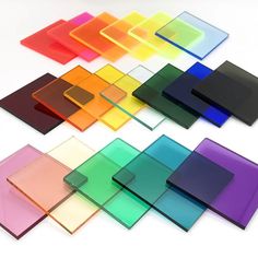 many different colored glass squares on a white surface