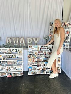 a woman standing in front of two shelves with photos on them and the word avary spelled out