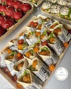 several trays filled with different types of wraps and fruit on top of each other