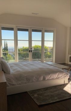 a large bed sitting in the middle of a bedroom next to two sliding glass doors