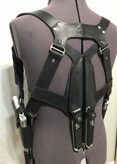 the back of a mannequin's torso with leather harnesses on it