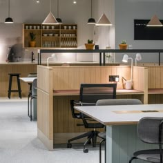 an office space with desks, chairs and lights hanging from the ceiling above them