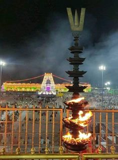 the fire is lit up in front of an ornate structure with lights and people around it