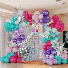 the balloon arch is decorated with stars, balloons and disco balls for a birthday party