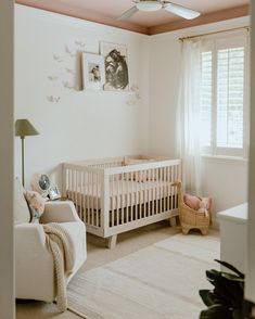 a baby's room with a white crib and pink walls