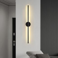 a black and white photo of a modern light fixture on the wall next to a bed