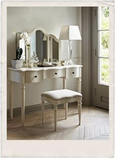 a white dressing table with mirror and stool