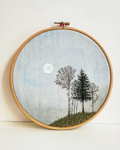 an embroidery project with trees and moon in the sky