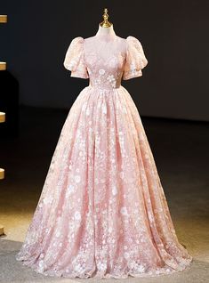 Hitch your dreams to the stars in this enchanting blush prom dress. Radiant with the soft glow of a blooming garden at dusk, its lace-embellished bodice sparkles with delicately sewn sequins. The puff sleeves float like gentle clouds, offering a dreamy silhouette. The skirt, a full cascade of layered tulle, offers a balletic grace that will turn the simplest walk into a majestic procession. This dress doesn't just shine; it illuminates, making every moment in it unforgettable.Silhouette:ball gownHemline:floor lengthNeckline:high neckFabric:laceShown Color:pinkSleeve Style:puff sleeveBack Style:lace upEmbellishment:beadingBuilt-in Bra: yes Pink Lace Wedding Dress For Prom Season, Pink Lace Ball Gown With Sweetheart Neckline, Pink Lace Bodice Dress For Quinceanera, Pink Ball Gown With Lace Bodice For Prom, Pink Lace Bodice Ball Gown For Prom Season, Pink Lace Prom Gown, Pink Lace Fitted Ball Gown, Pink Quinceanera Dress With Lace Bodice, Pink Ball Gown Quinceanera Dress With Lace Bodice