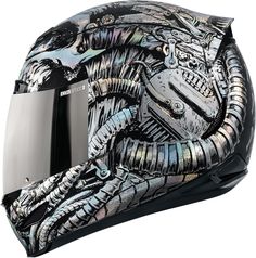 a motorcycle helmet with an alien design on the front and side, as if it were painted in metallic