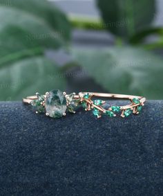 an image of a ring with green stones on the front and back of it's band