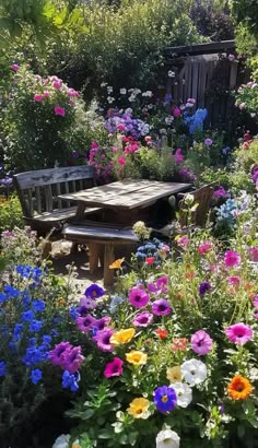 a wooden table surrounded by colorful flowers in a garden