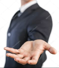 a man in a suit is holding out his hand