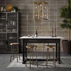 a dining table with three stools next to it and a wine rack in the background