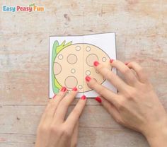 two hands are holding an easy peasy fun printable card with the image of a pineapple on it