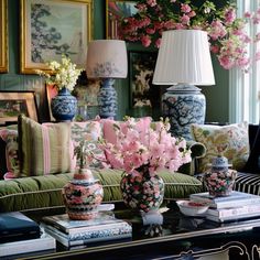 a living room filled with lots of furniture and flowers in vases on top of a table