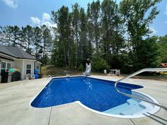 an empty swimming pool in front of a house