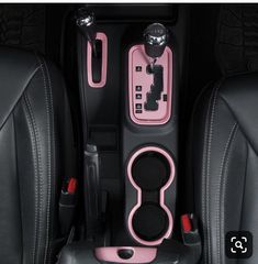 the interior of a car with pink and black trims, steering wheel controls and center console