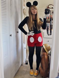 a woman in mickey mouse costume posing for the camera