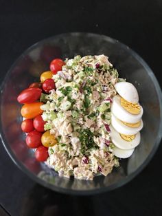 a salad with hard boiled eggs, tomatoes and lettuce is shown in a glass bowl