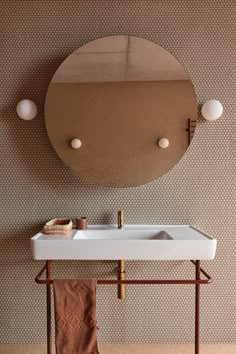 a white sink sitting under a mirror next to a wall mounted faucet in a bathroom