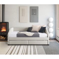 a living room with a white couch, fireplace and rugs on the floor in front of it