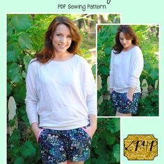 a woman standing in front of green plants wearing shorts and a white shirt with the words sewing pattern on it