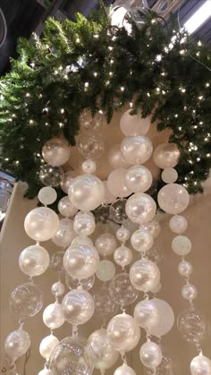 christmas decorations hanging from the ceiling in a room with lights and garlands on it