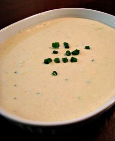 a white bowl filled with soup on top of a wooden table