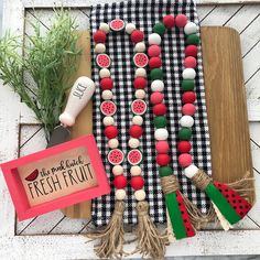 an assortment of fruits and vegetables are displayed on a wooden board with a sign that says fresh fruit