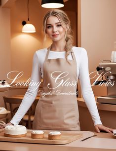 a woman in an apron standing behind a counter with cupcakes on the table